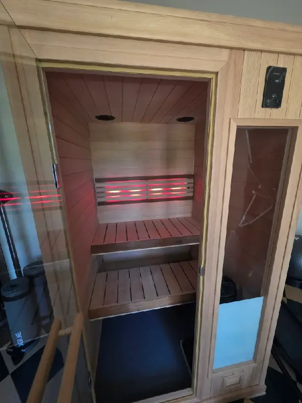 A two-person sauna installed in a residential garage, showing how unused garage space can become a comfortable private wellness retreat for couples and homeowners.